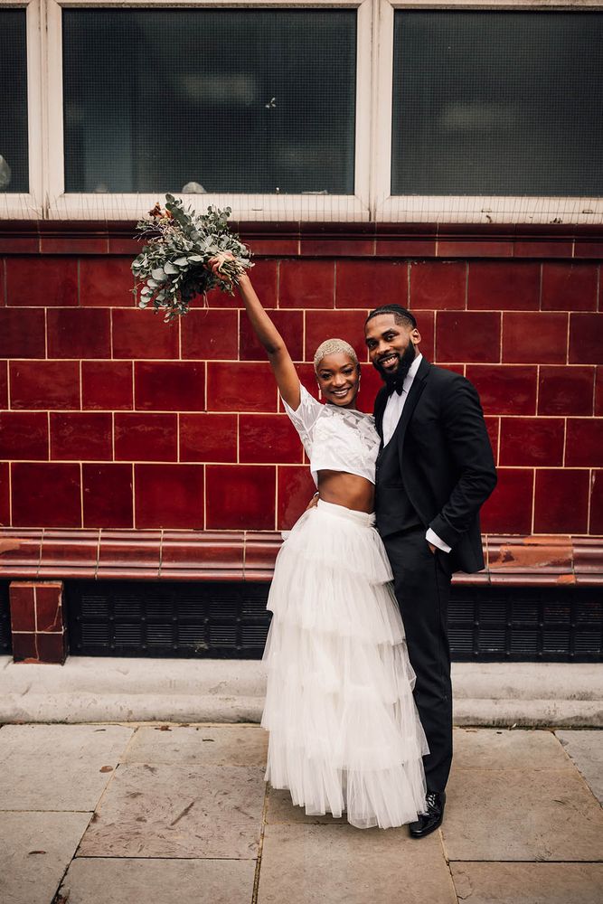 Black bride wears ruffle layered skirt complete with lace cropped top for bridal two-piece set 