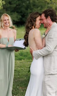 Celebrant smiling as the bride and groom share a moment during the wedding ceremony – Celebrants