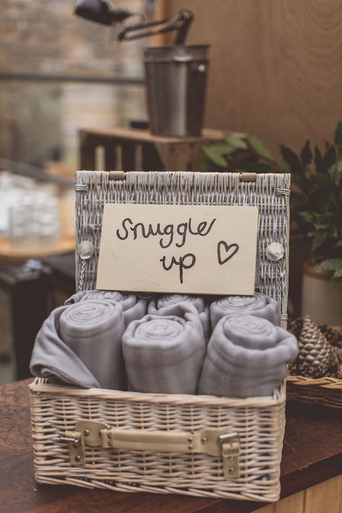 A basket full of rolled up blankets with a sign reading 'Snuggle Up'
