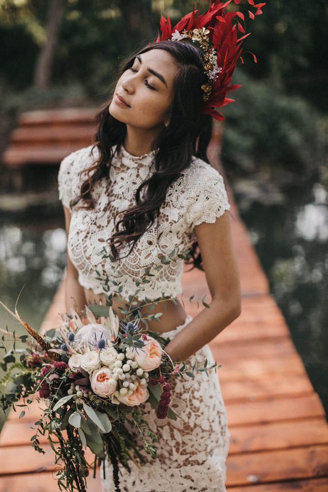 Bride wears feather bridal crown complete with short sleeved fitted lace bridal separate 