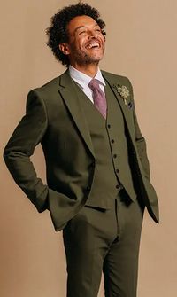 Groom smiling wearing a dark green wedding suit with pink tie and white shirt - Menswear