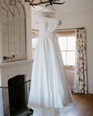 Off the shoulder wedding dress on personalised white hanger