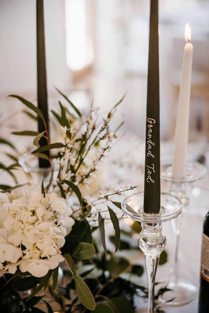 Dark green taper candles with names on wedding favours 