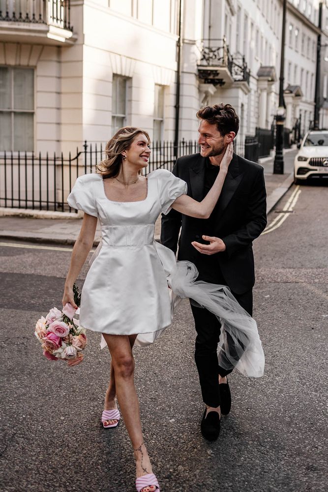 Bride in a short wedding dress with puffed sleeves and bow styling to the back complete with a square neckline 