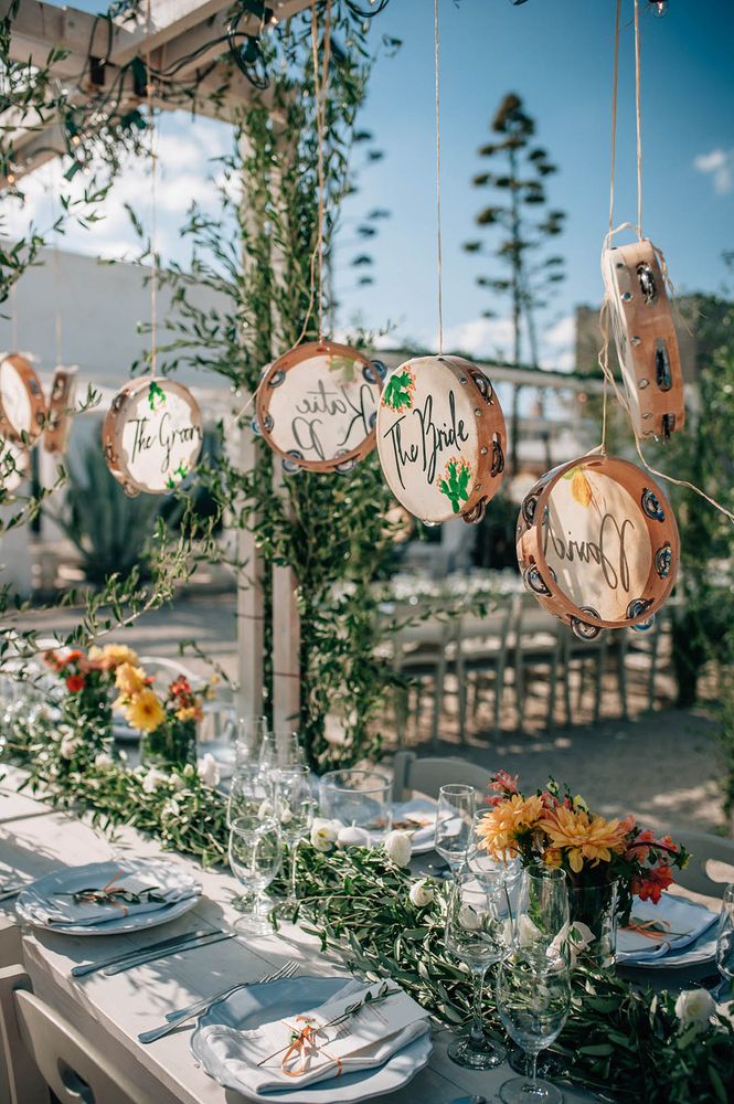 Tambourines hanging act as place names and wedding favours for the guests 