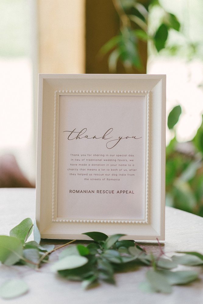 Wedding thank you sign in white frame stating that the couple have gifted to charity as an alternative to wedding favours 