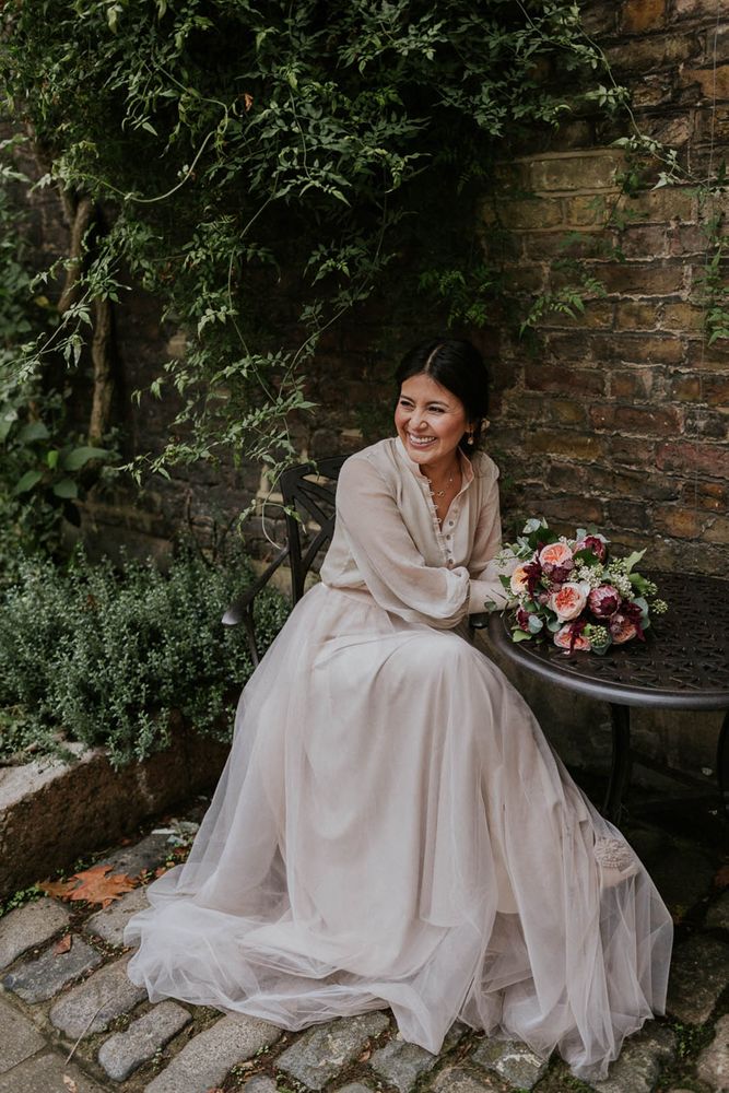 Bride wears chic buttoned blouse and tulle skirt bridal separates in neutral tones 